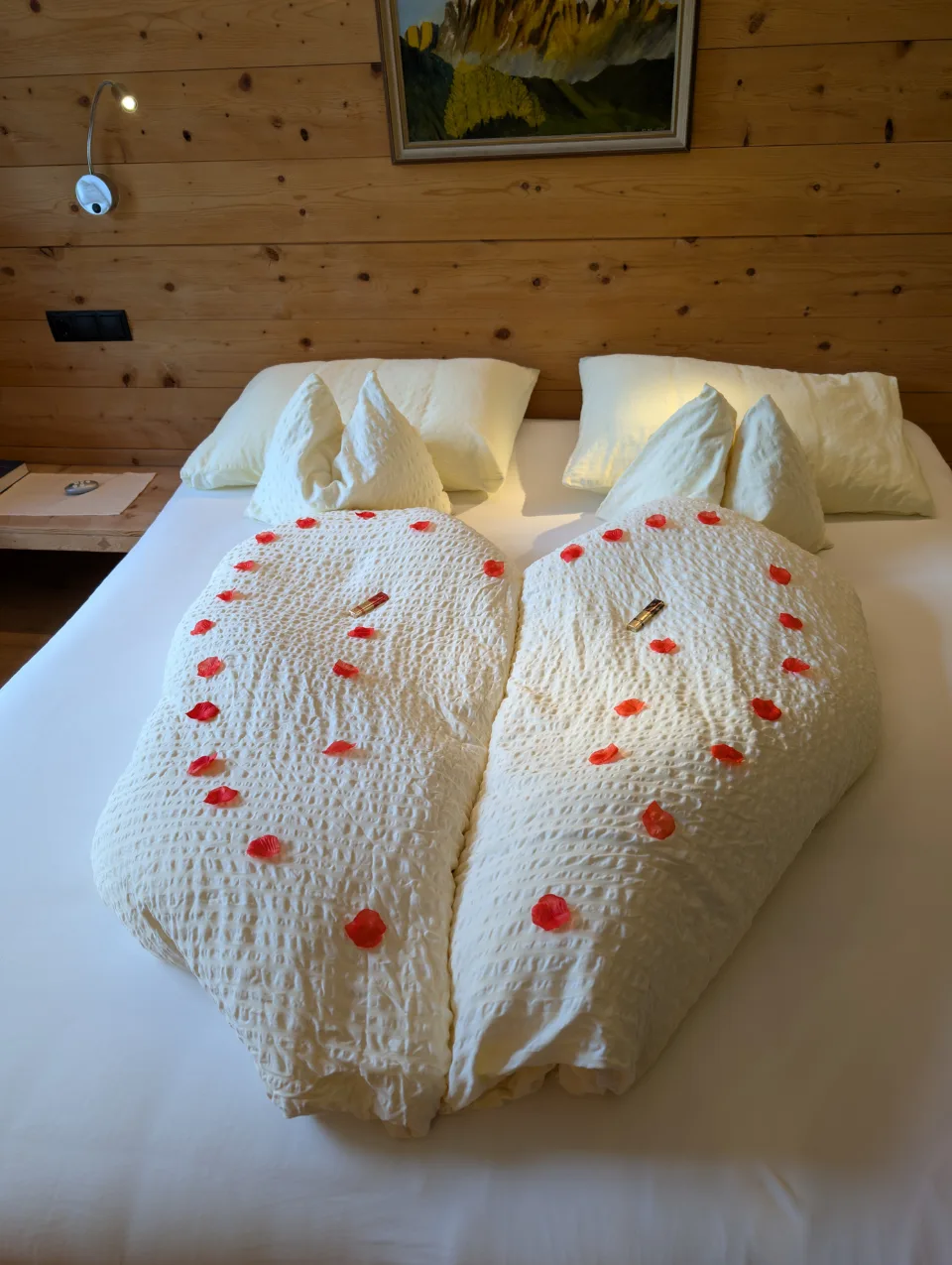 Hotel bed with rose petals on a birthday evening