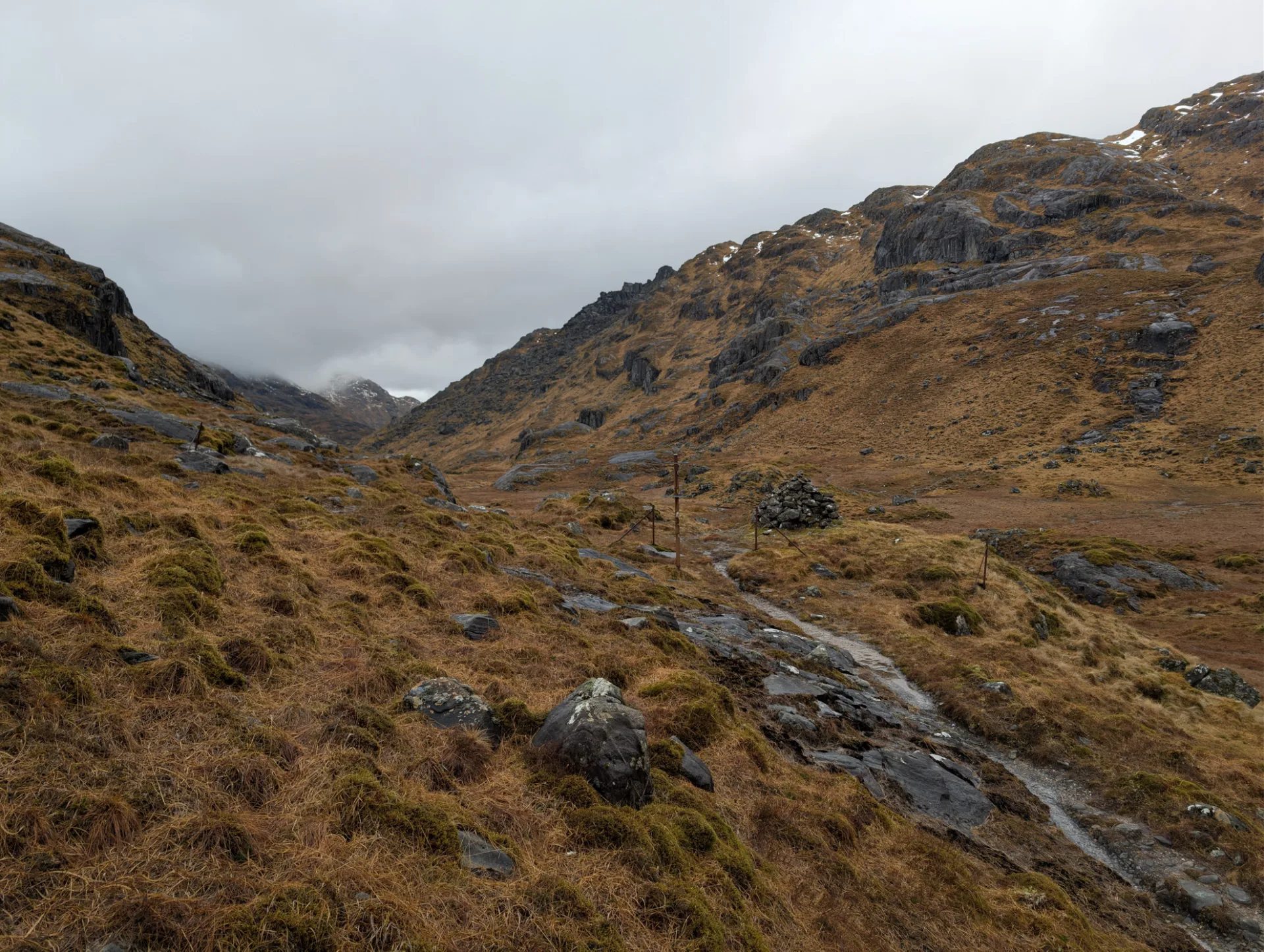 Mountains in cloud, the path winding through the heather
