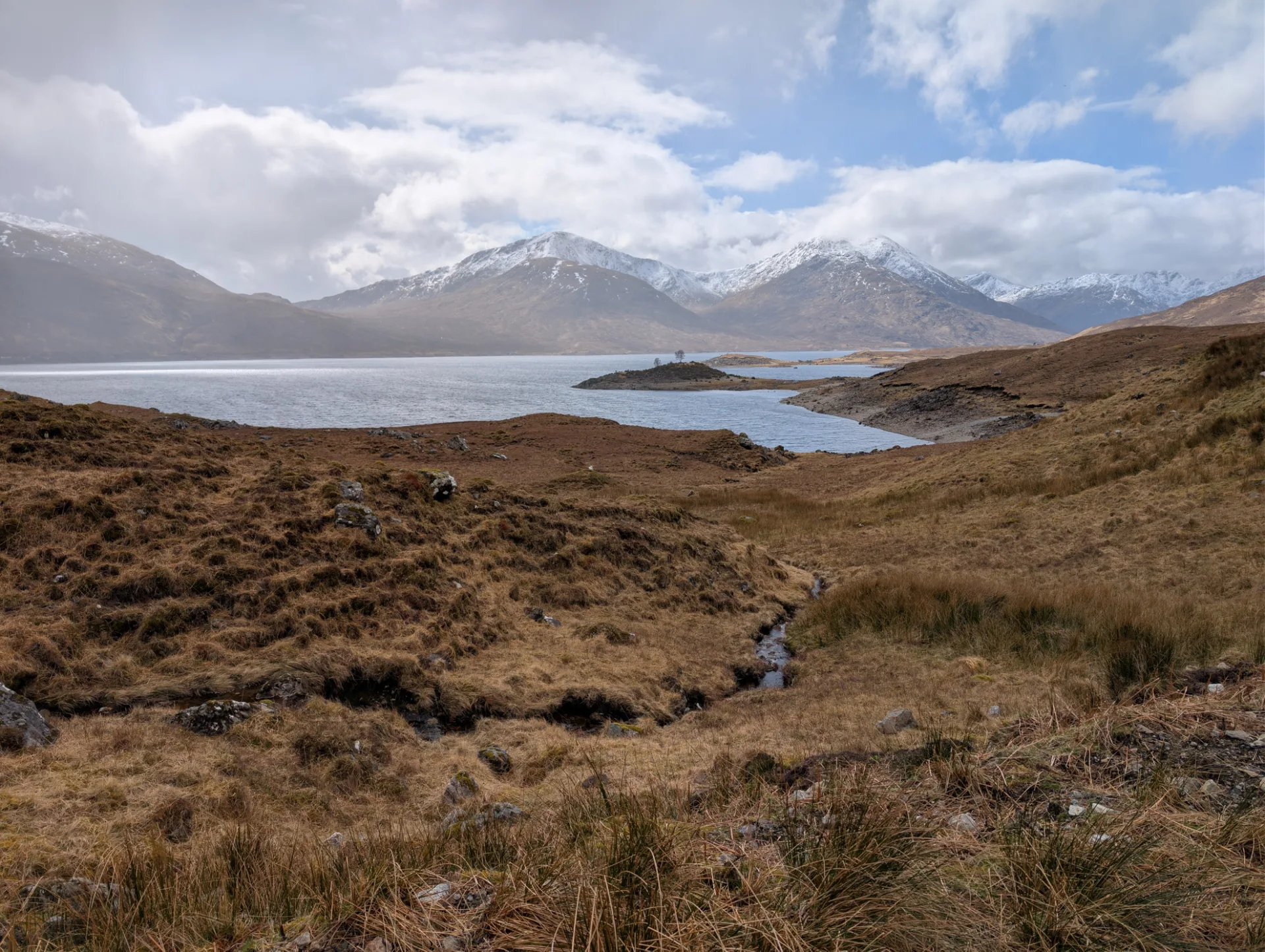 Loch with a tiny island in late sunlight