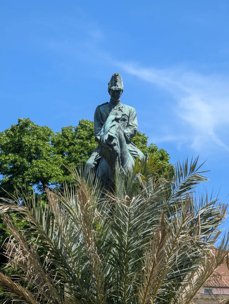 Bronze equestrian statue among palms near the Forum
