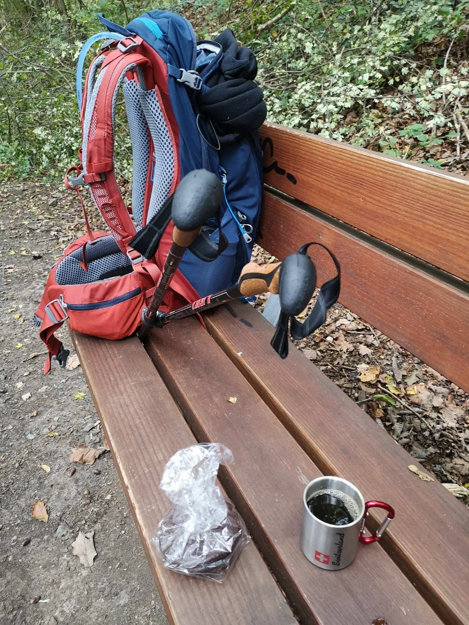 A midday rest on a bench: backpack and poles set down, roughly halfway after a good thirty kilometres.