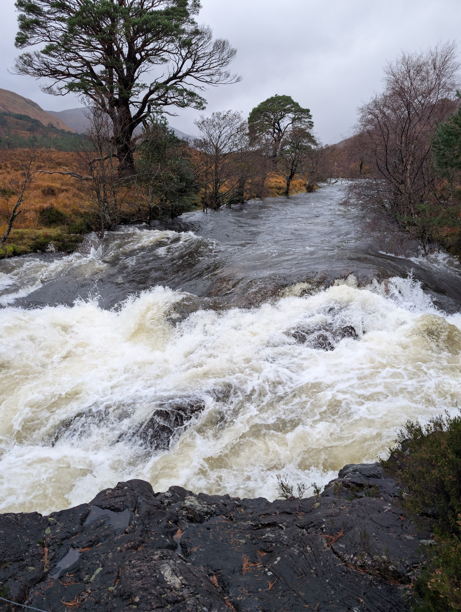 Roaring waterfall in the Scottish highlands — powerful water over rock steps