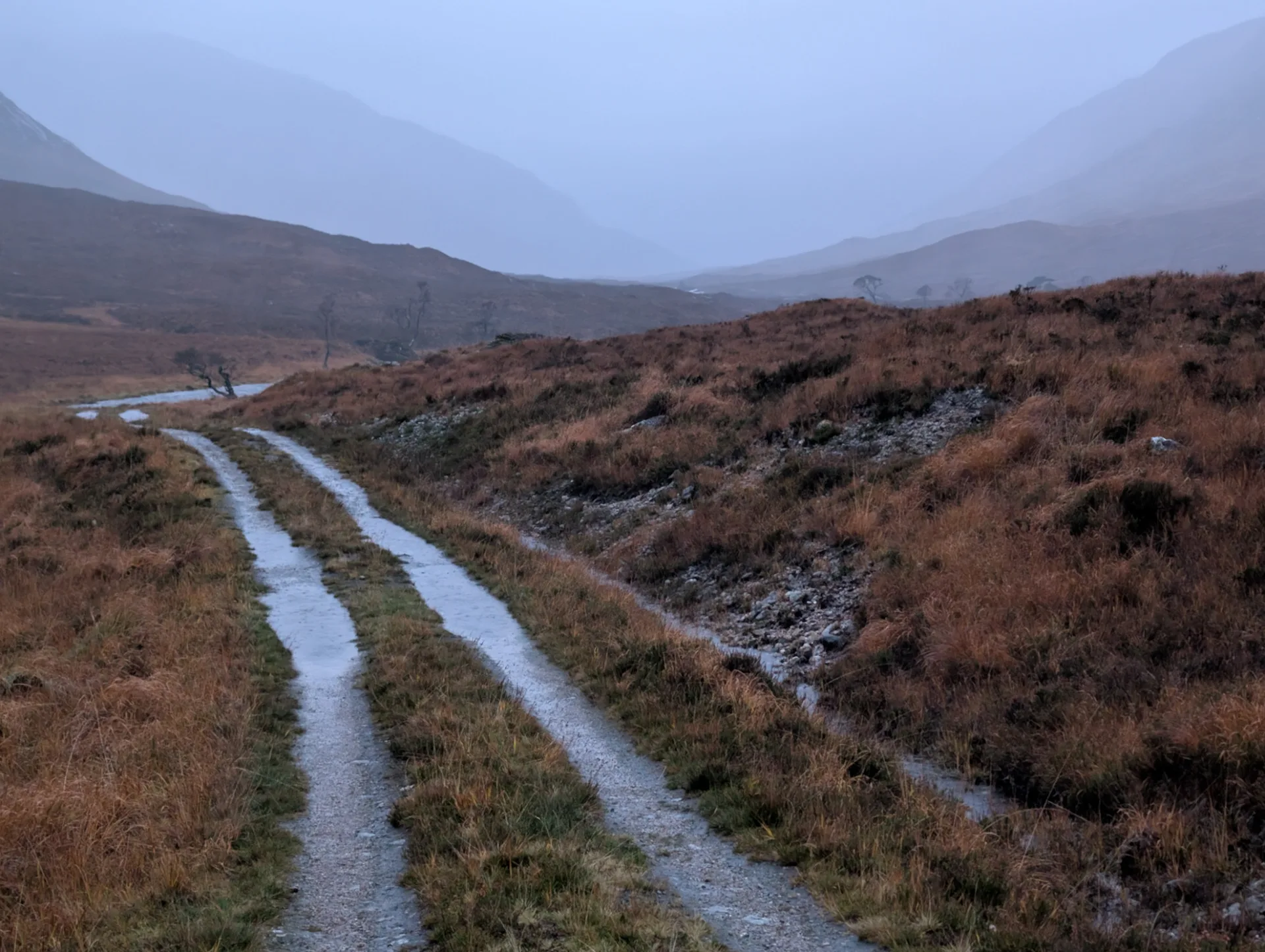 Atmospheric twilight over the gravel path, mist filling the valley