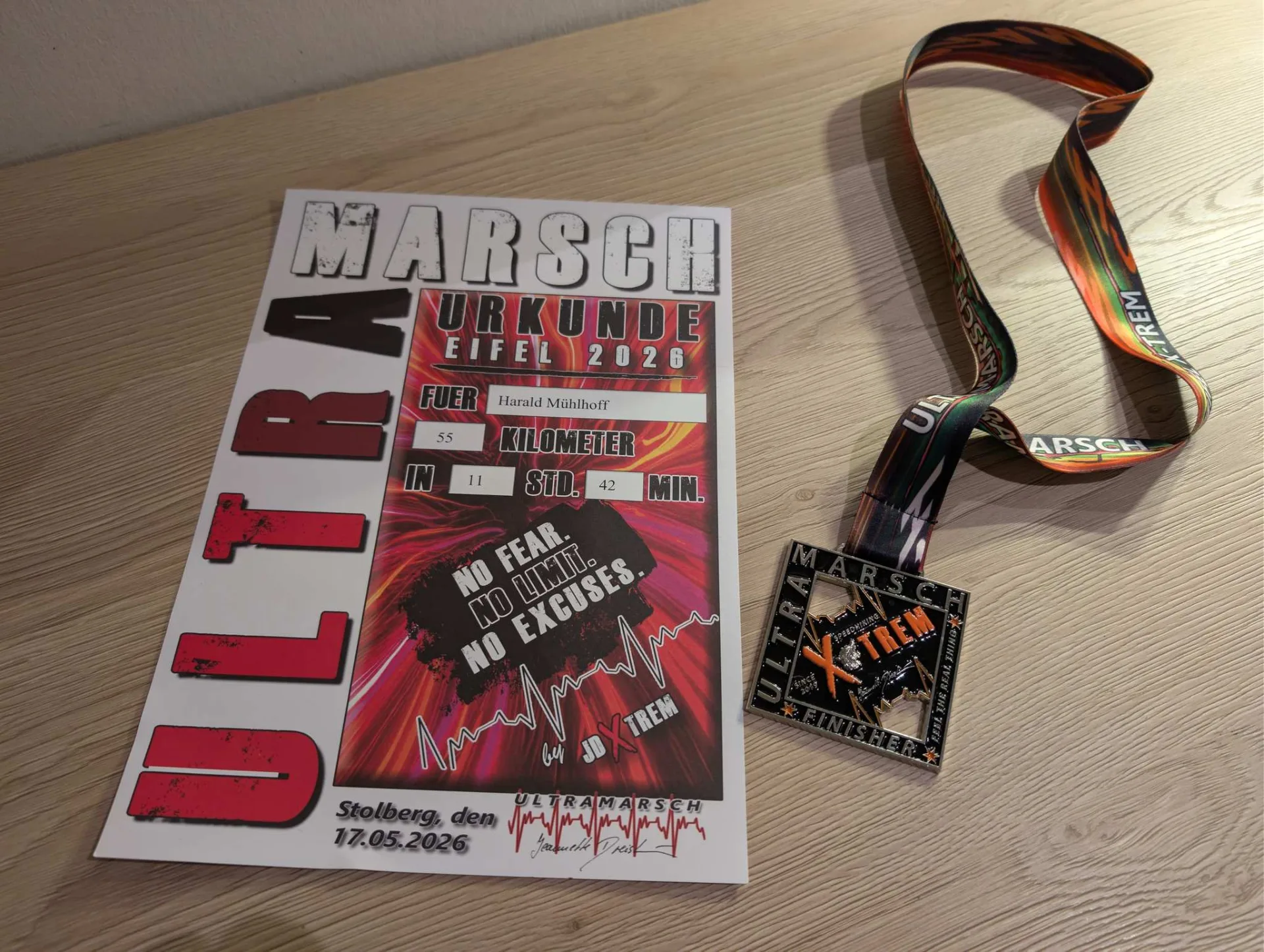 At the finish: certificate and medal — 55 kilometres in 11 hours 42 minutes.