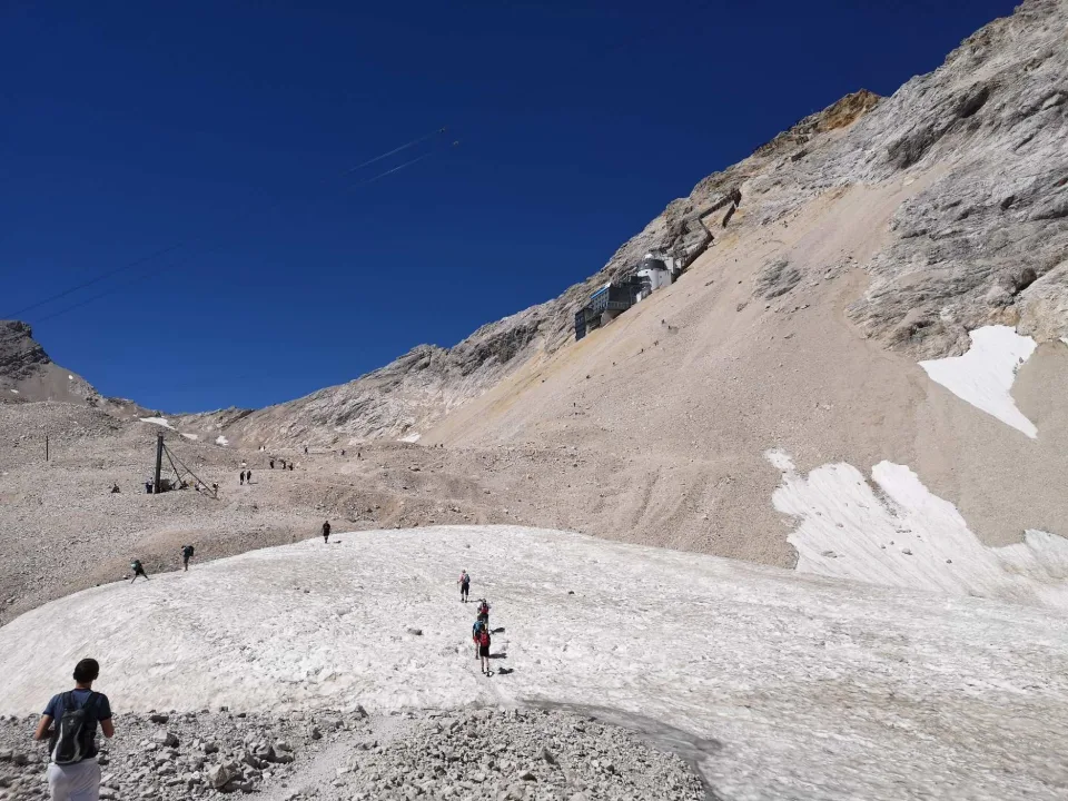 The Zugspitzplatt: a barren high plateau of scree and lingering snow, the hikers mere dots within it.