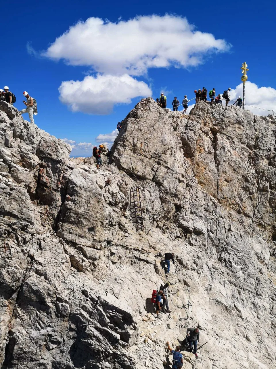 The cable-secured final climb to the summit platform — and the crowds at the cross.